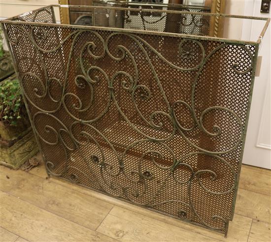 A wrought iron and mesh fire guard W.114cm